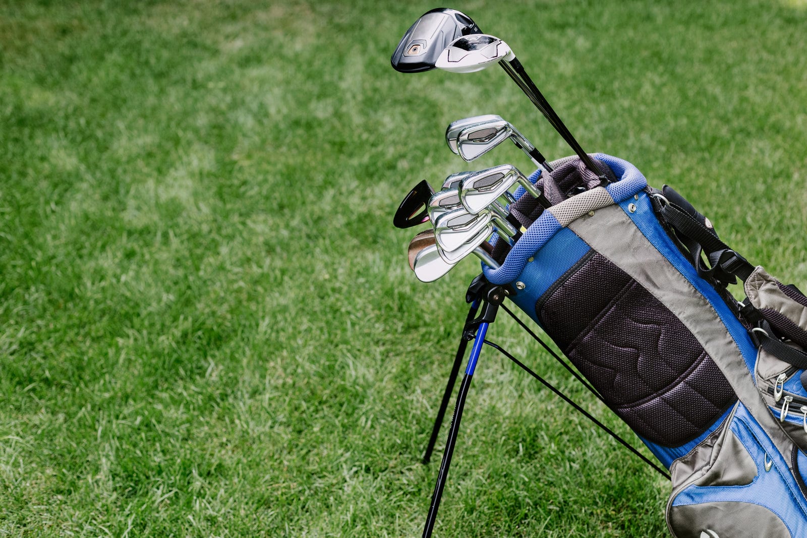 Golf bag full of clubs resting on a golf course