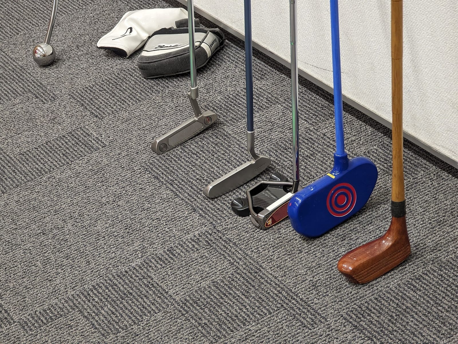 Indoor golf practice bay with a hitting mat facing an enclosure screen