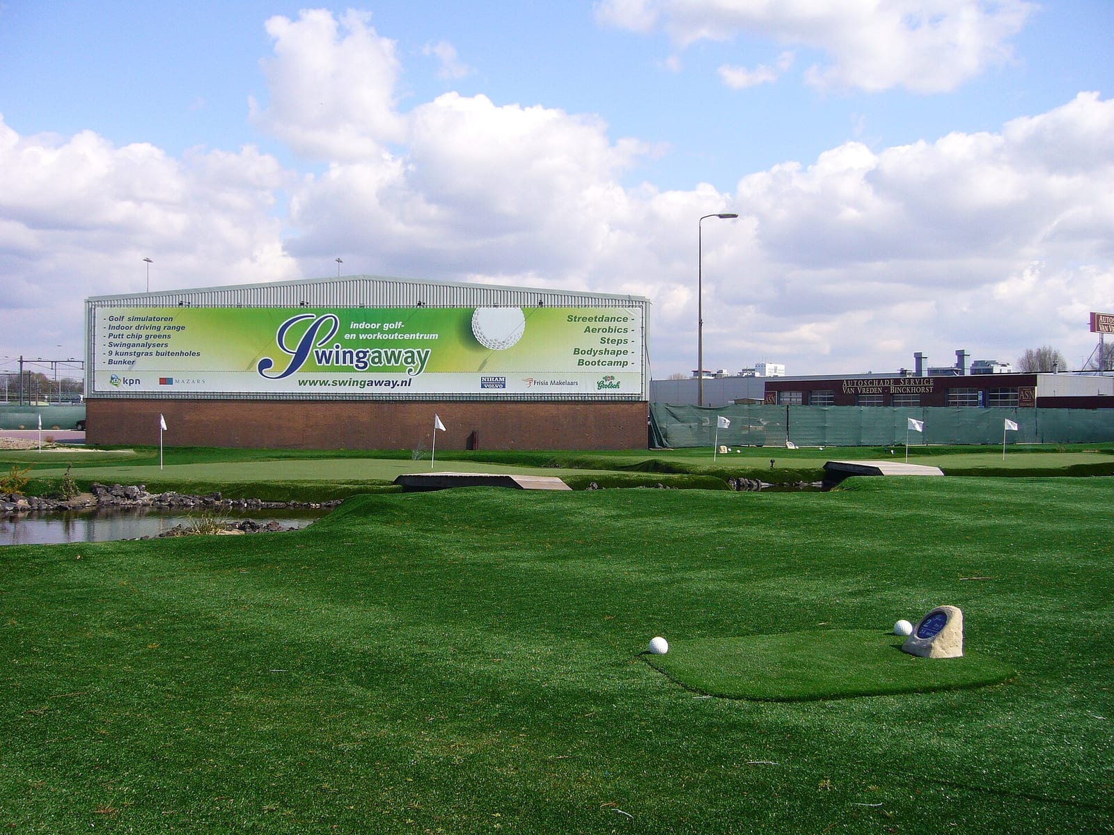 Interior of an indoor golf facility with a large projected screen