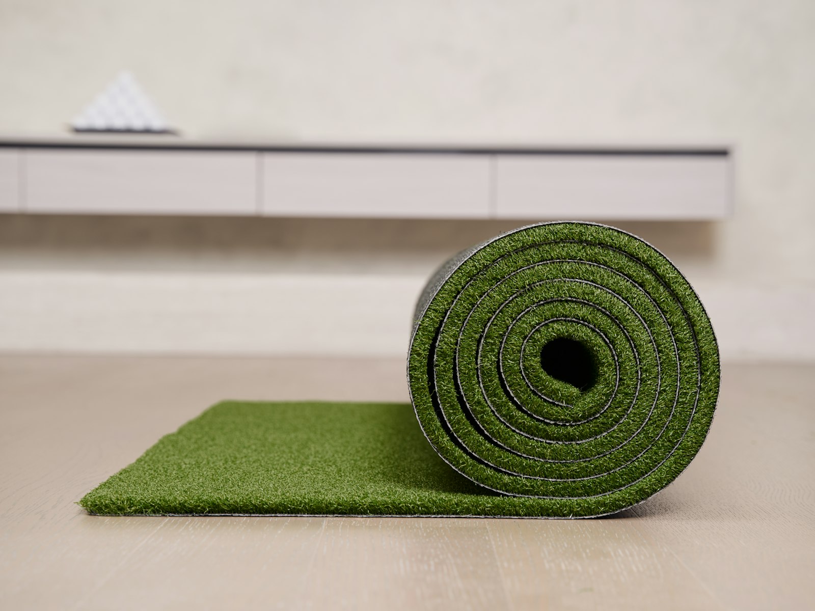 Rolled artificial turf mat on a wooden floor