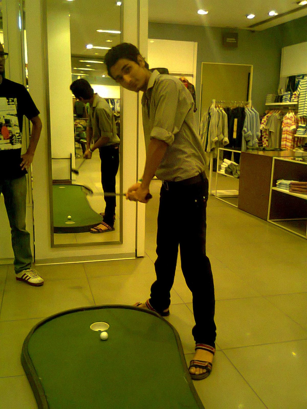 Indoor golf practice setup with a hitting mat and clubs