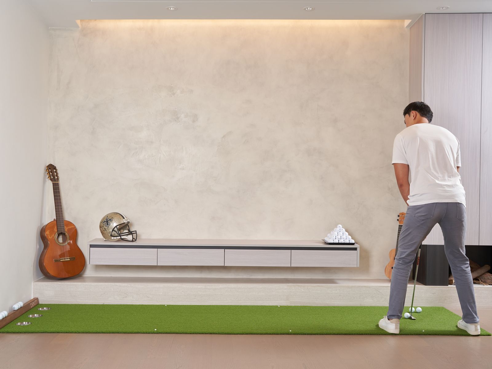 Golfer practicing on a putting mat indoors with no enclosure