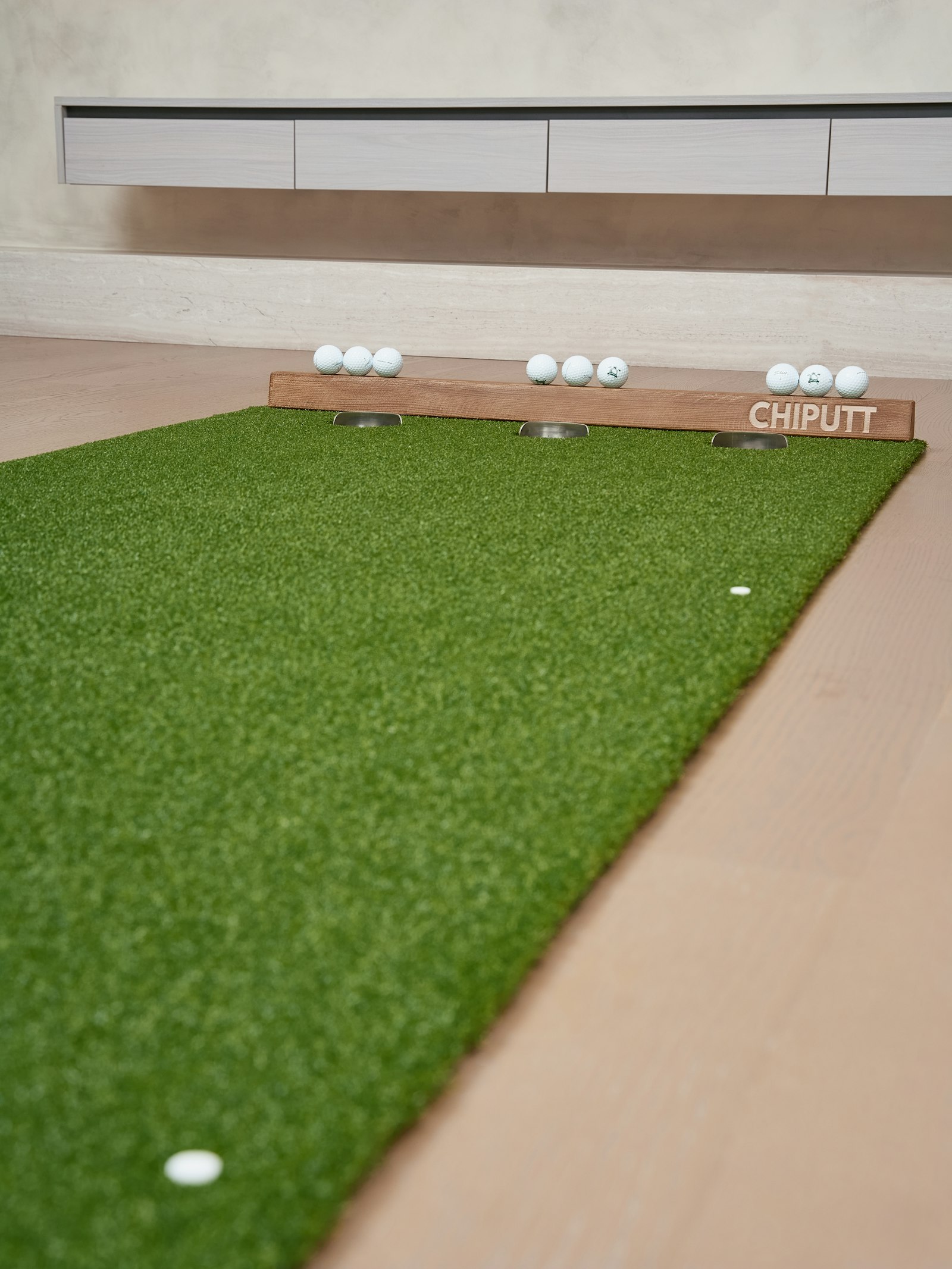 Putting mat with a wooden backstop