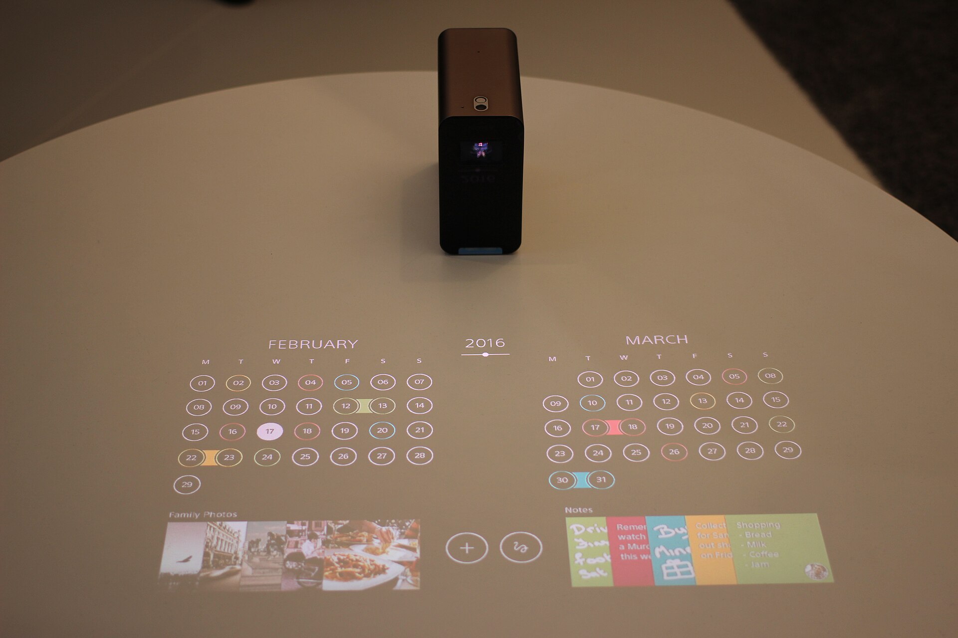 A short-throw projector unit sitting on a media stand
