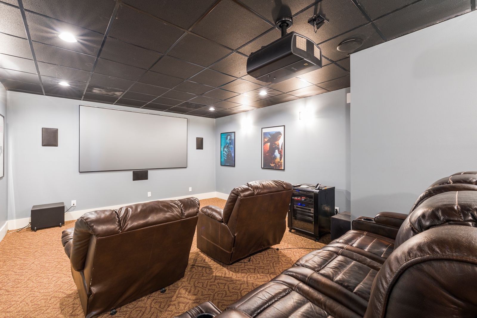 A cozy home theater setup with leather recliners and audiovisual equipment