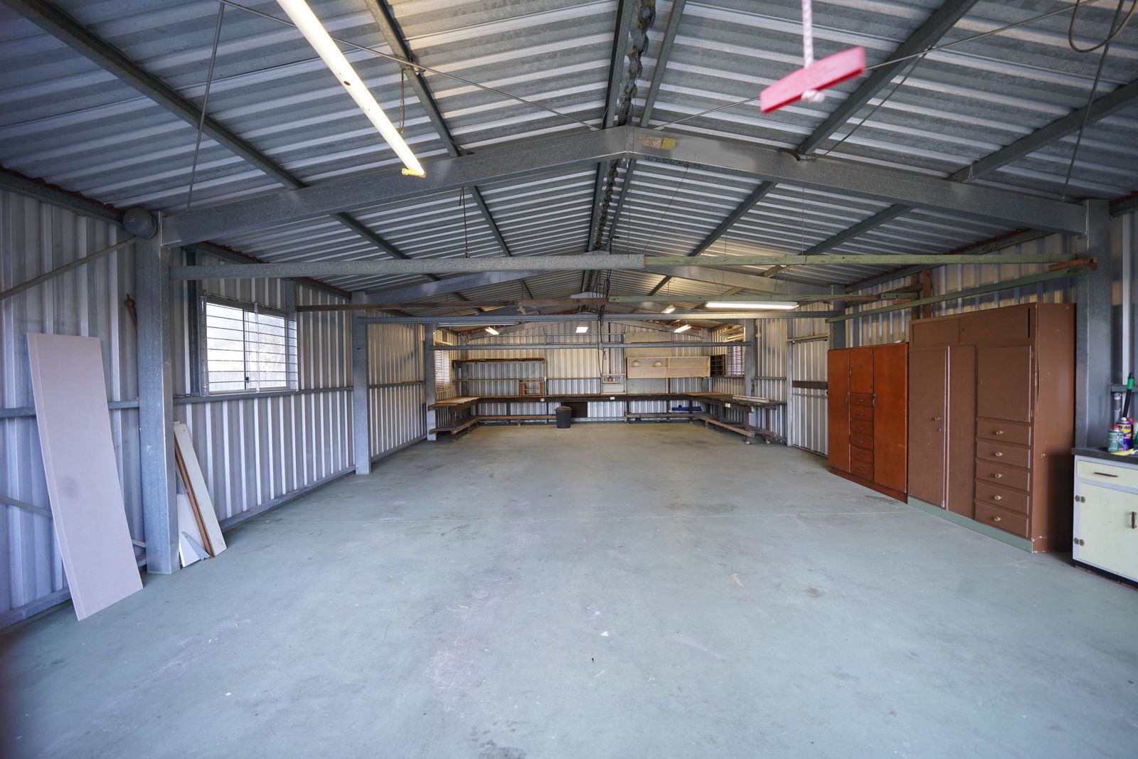 An empty garage bay with metal walls and a bare concrete floor, ready for a build