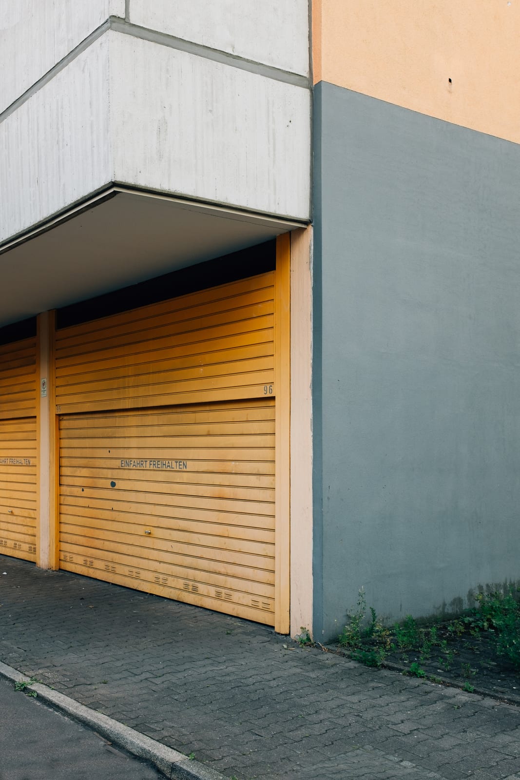 The exterior of an industrial garage door beside a concrete wall