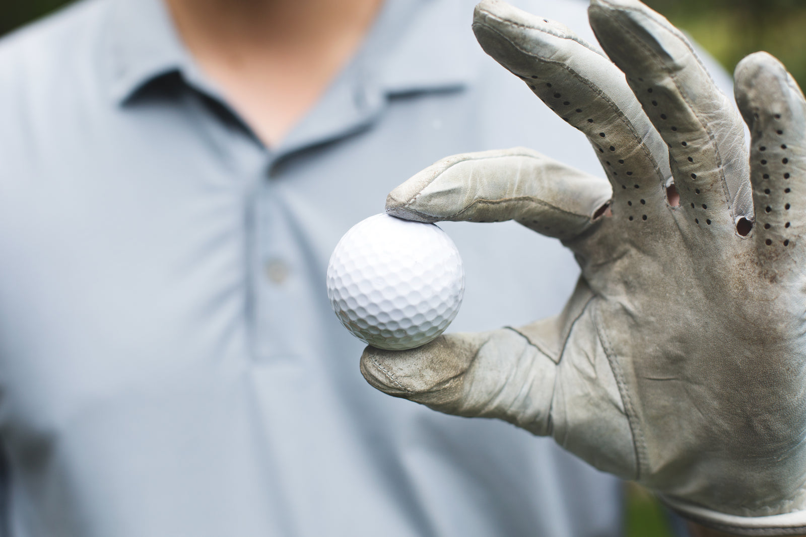 A golfer holding a golf ball before teeing it up