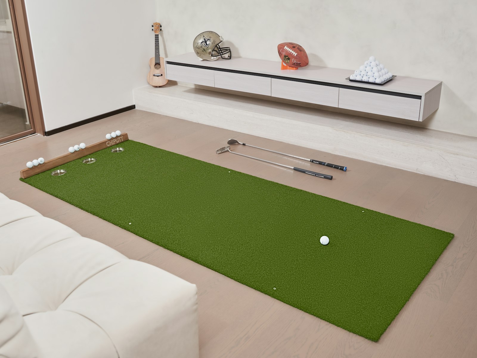 An indoor putting green with a putter and golf ball