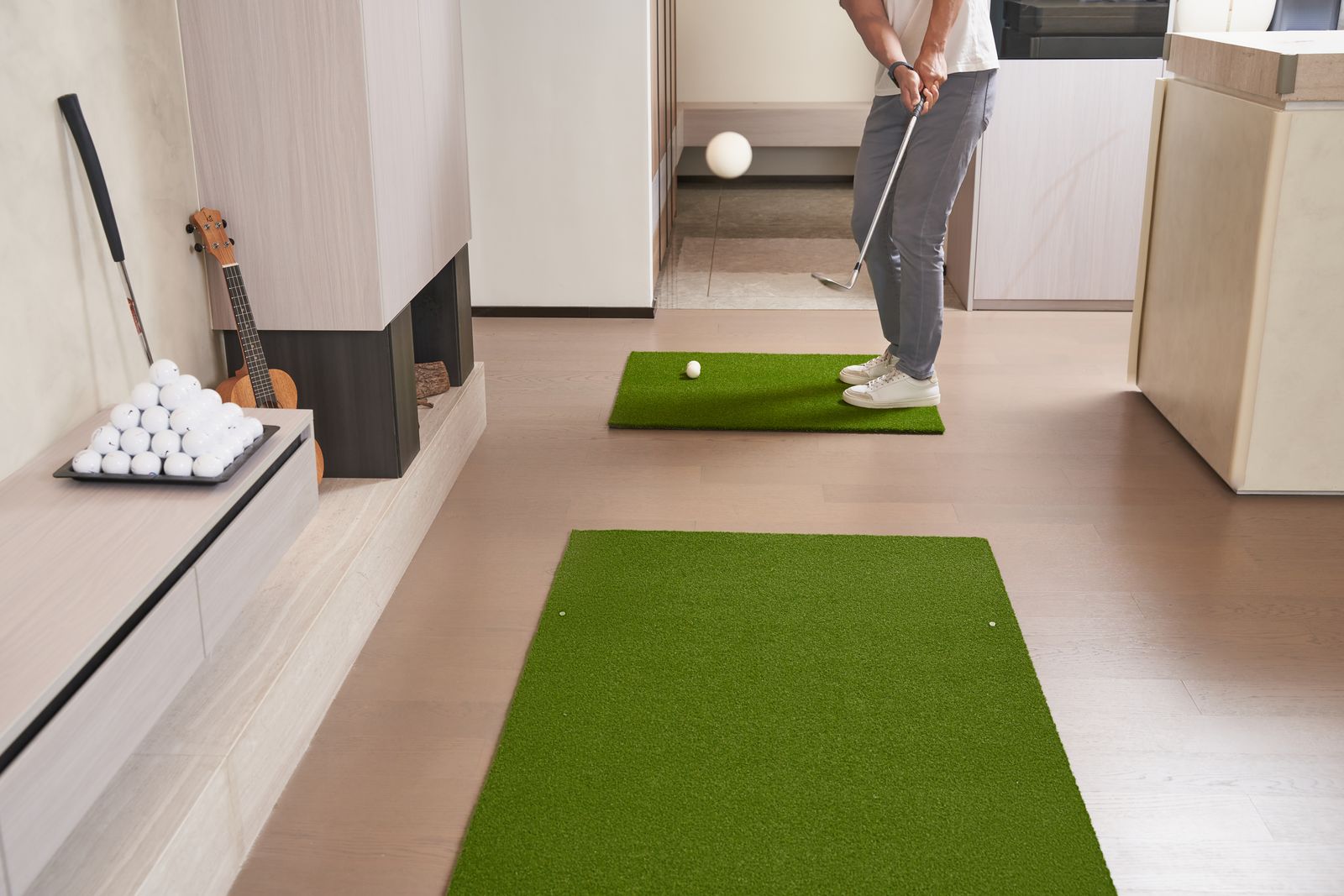 Indoor golf practice on artificial turf with practice equipment set up