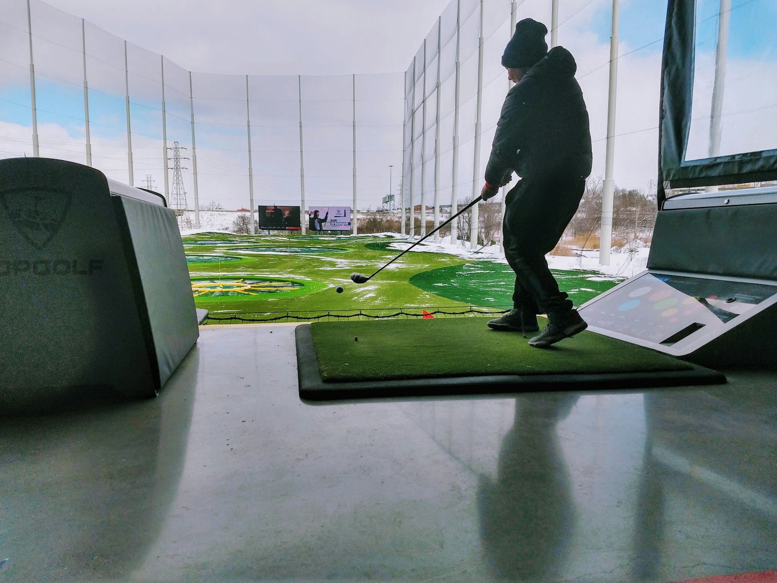 A golf club mid-swing in cold weather