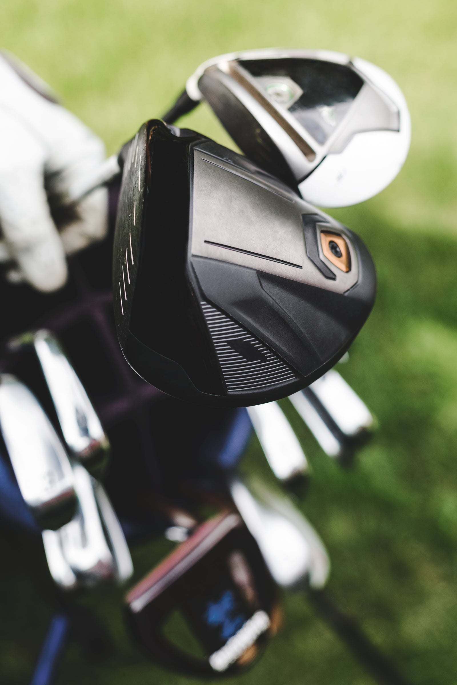 A golfer pulling a driver from a golf bag on the course