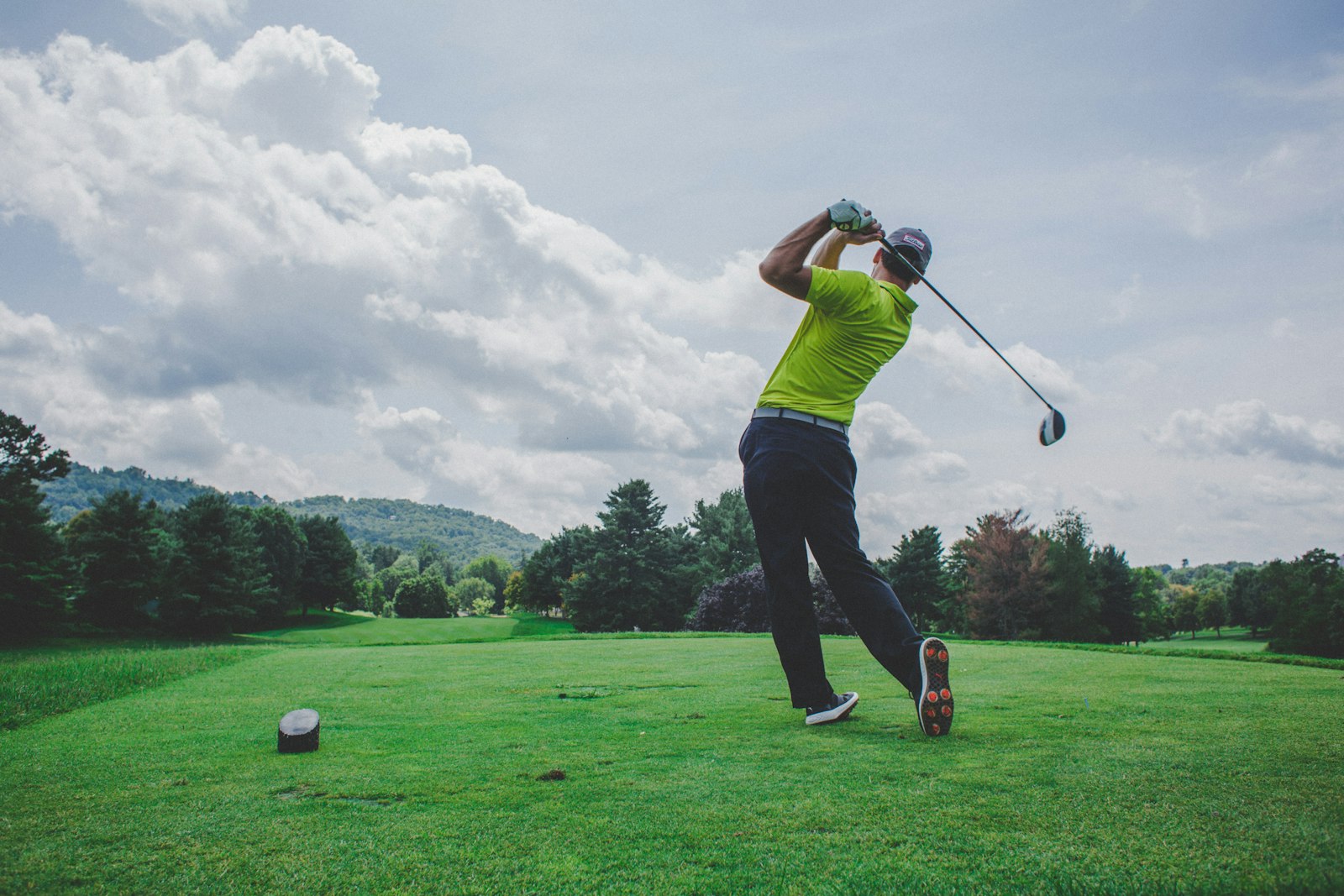 A golfer swinging a driver, mid-motion